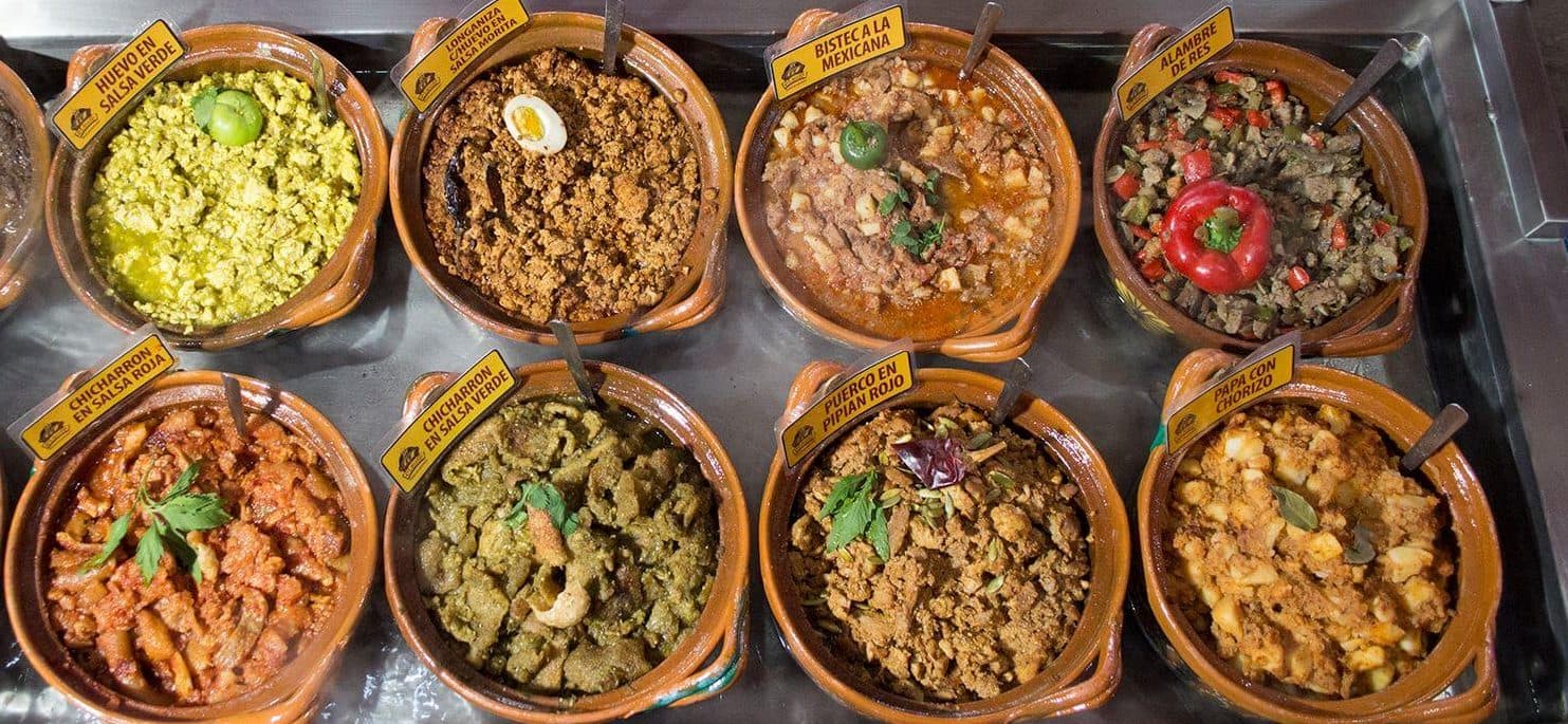 Cazuelas de barro con guisados, cada una con la etiqueta de su platillo